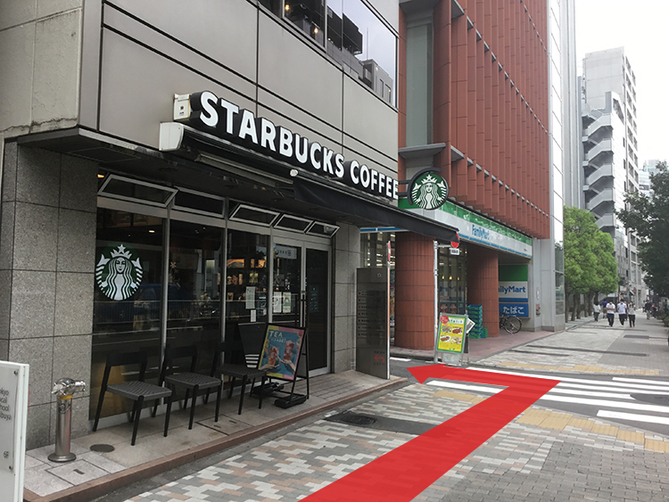 明治通り沿いのスターバックスとファミリーマートの間の路地に入り、スターバックスの建物沿いにお進みください。